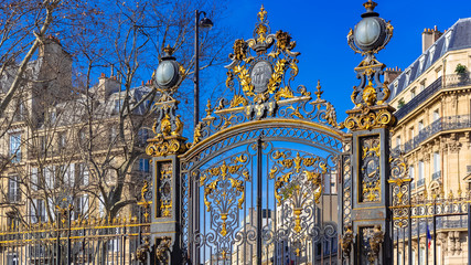 Paris, in the beautiful parc Monceau, the golden wrought iron grid, with typical buildings in background  - obrazy, fototapety, plakaty