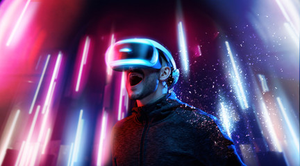 Model young man with beard in glasses of virtual reality. Augmented reality, science, future technology, people concept. VR. Futuristic 3d glasses with virtual projection. Neon light.