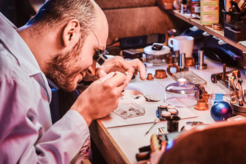 Smart watchmaker is restoring cutomer's watch at his own repairing studio.