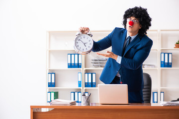 Young clown businessman working in the office 