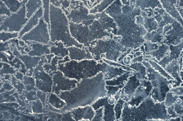 Texture abstract closeup background ice with grooves, furrows, and bubbles of air cought by frost in the mass of wated while freezing