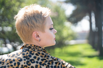 sexy curvy blonde woman with short hair wearing latex rubber catsuit and tight fetish corset....