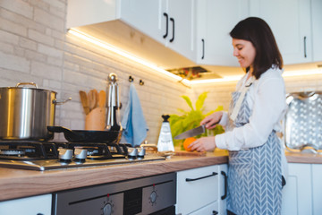 woman cutting orange at the domestic kitchen