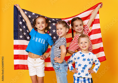 group of children with flag of   United States of America USA on yellow   background.