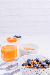 Traditional european breakfast on white wooden background. Muesli with berries, coffee and orange juice.