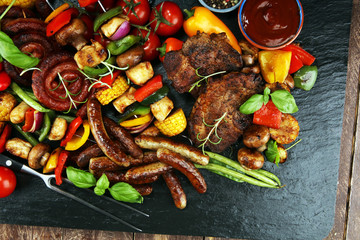 Assorted delicious grilled meat and skewer with vegetable on rustic table