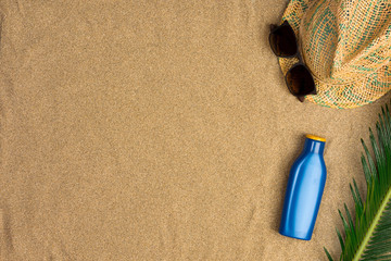 Fototapeta na wymiar Space for text, beach theme on sand background. Hat, sunglasses, sunscreen on sand background. Top view.
