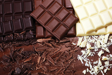 chocolate in diffrent color. milk, dark and white chocolate bars on table