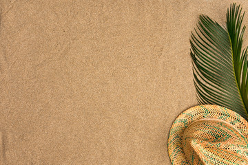 Fototapeta na wymiar Minimalist summer flat lay with, palm leaves and panama hat on sand background
