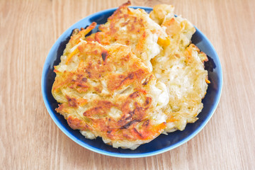 Diet vegetable cutlet from carrot, zucchini, potato on wood table. Healthy food