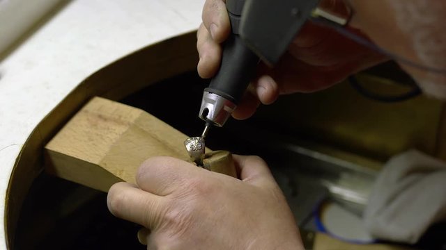 Jeweler in the workshop engraves the ring