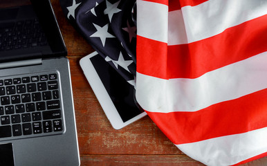 Tablet pc computer on american flag, technology, patriotism, anniversary, national holidays and independence day