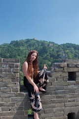 Fototapeta premium Fashionable female caucasian tourist posing on Great Wall of China