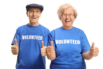 Cheerful senior couple volunteers with thumbs up