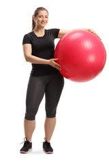 Young smiling woman posing with a fitness ball