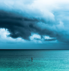 A paddle boarder coming in ahead of a summer thunderstorm in Treasure Island, Florida