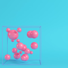 Abstract spheres in wire box on bright blue background in pastel colors. Minimalism concept