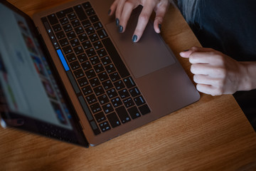 Top view of girl hands typing on keyboard of laptop