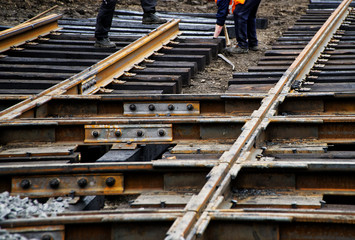 Workers assemble wooden sleepers and tram rails during the repair of city roads. Urban economy