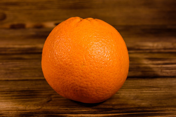 One orange fruit on a wooden table