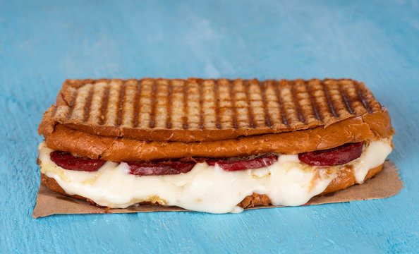 Sausage and cheddar cheese toasts on blue wooden background