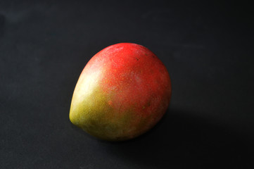 photos of delicious fresh mango with dark background isolated.