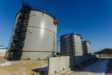 Large silver tanks for the storage of petroleum products in the open. Oil storage.