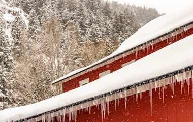 Icicles hanging from the roof of a red building in Kamas, Utah, USA. 