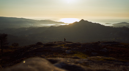 Silhouette of a person contemplating an enormous landscape from Mount Galiñeiro in Vigo, Spain