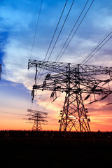 In the evening, the silhouette of high voltage towers