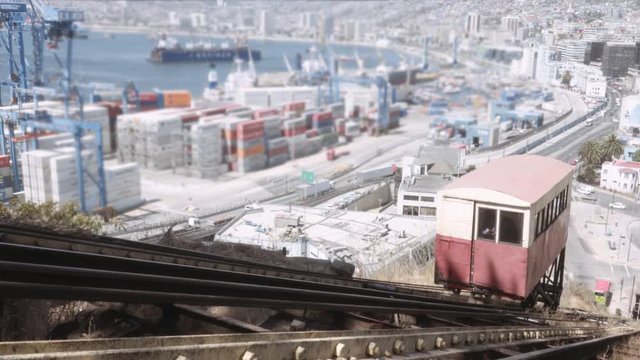 Funicular reaching the station, detail of the operating cables of the railroad car. Panoramic view of the commercial port of  Valparaiso City. 4k