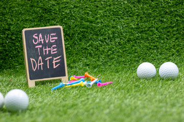 Golf Save the date with golf balls and tee on green grass