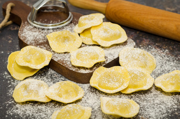 Uncooked fresh homemade tomato and mozzarella ravioli. Italian cuisine - raw ravioli, made of flour and egg