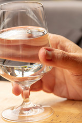 Glass of water being held by a person at a restaurant