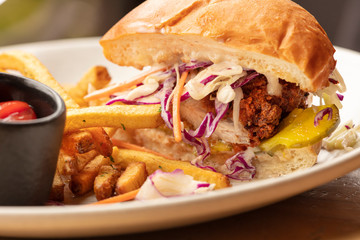 Fried chicken sandwich on a burger bun and a side of french fries and ketchup