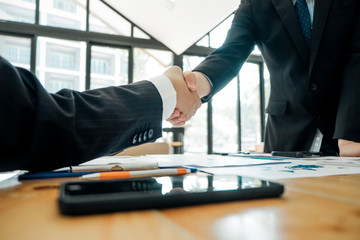 Businesspeople partners shaking hands after complete agreement plan in meeting room, investment concept, success concept