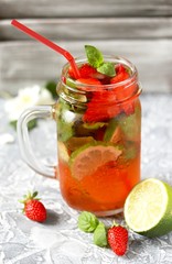 Mojito lemonade with strawberries on a dark background in a trendy mug pot.