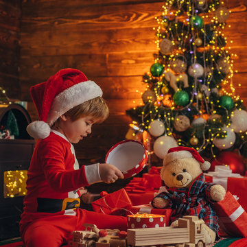 Christmas Attributes. Family Holiday. Childhood Memories. Santa Boy Celebrate Christmas At Home. Boy Child Play Christmas Decorations. Merry And Bright Christmas. Childhood Activity And Game