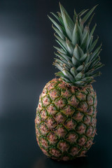 standing pineapple on an isolated black background with a slight reflection