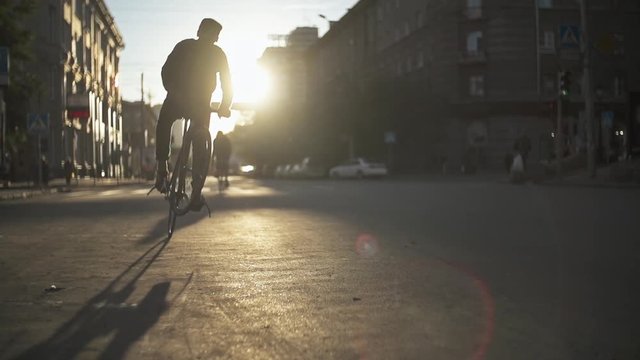 Group of cyclists riding fixed gear bicycles at street. Eco-friendly transport. Active lifestyle at urban environment. City streets without cars.