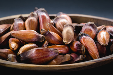 Brazilian pine in brown wooden rustic bowl. Typical araucaria tree seed used as a condiment in Brazilian cuisine in winter.
