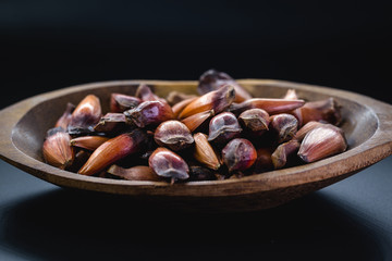Brazilian pine in brown wooden rustic bowl. Typical araucaria tree seed used as a condiment in Brazilian cuisine in winter.