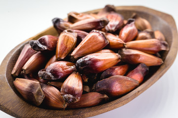 Brazilian pine in brown wooden rustic bowl. Typical araucaria tree seed used as a condiment in Brazilian cuisine in winter.