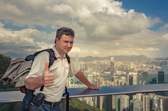 big strong guy with backpack pose on Victoria's peak, men showing big finger to the camera