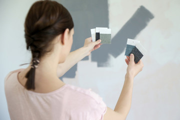 Young woman choosing a perfect shade of grey for walls in her new home