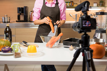 Woman recording video of her cooking for online video blog