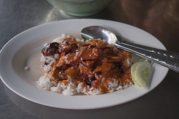 Barbecued red pork in sauce with rice on wood table. Thai food
