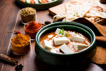 Paneer Butter Masala is a popular North Indian recipe for lunch/dinner made using cottage cheese in red tomato curry. usually served with Rice and chapati/naan. selective focus
