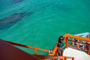Naklejka premium Black woman walking on the beach, contemplating the sea and making land