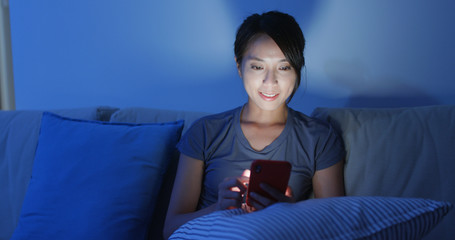 Woman work on mobile phone at home in the evening